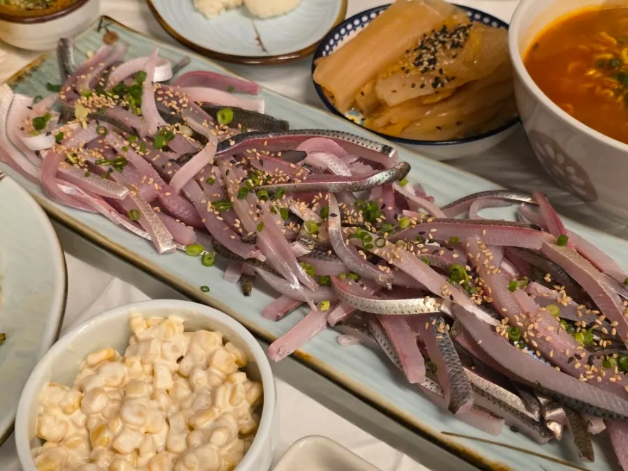 Table spread with jeoneo hoe and side dishes
