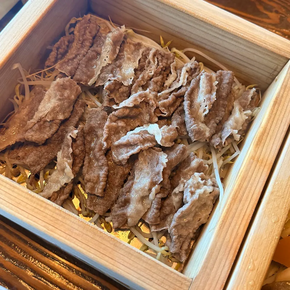 뚜껑을 연 편백나무찜 속 채소와 고기