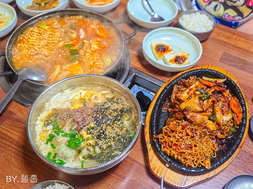 Table set with kimchi jjigae and hot-plate pork stir-fry