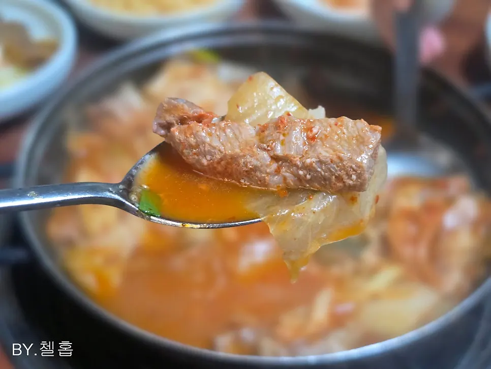 Kimchi jjigae broth with well-fermented kimchi and meat visible