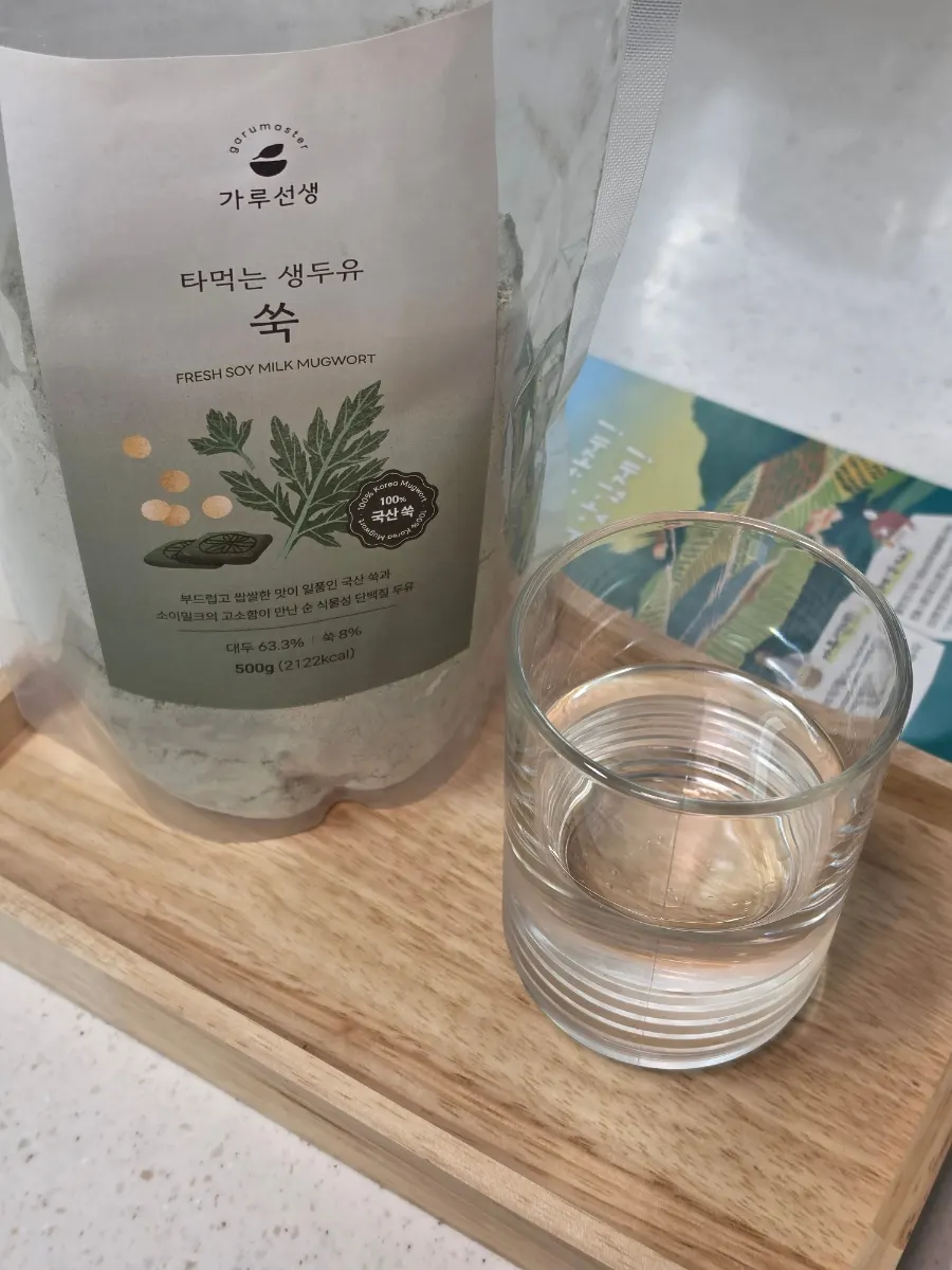 스푼으로 찬물에 쑥두유 가루를 젓는 모습