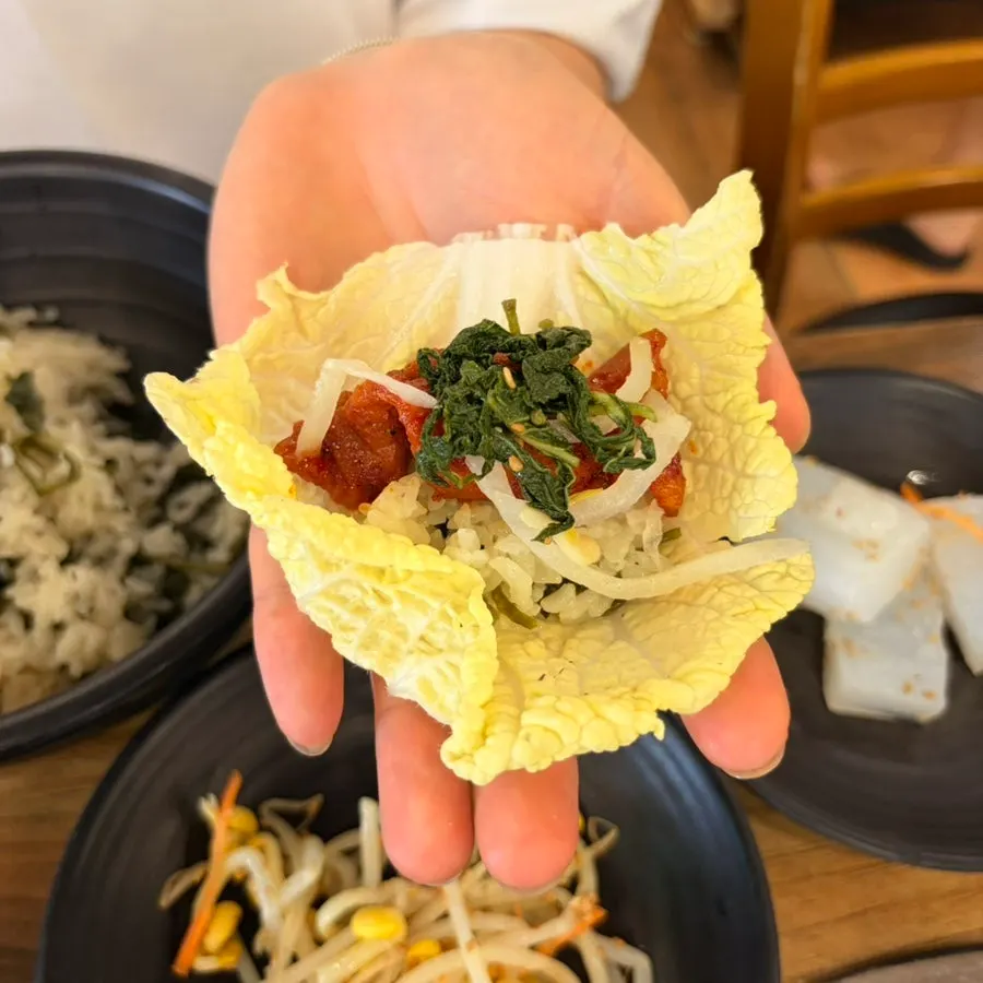 A spoonful of gondre-bap topped with a vegetable side