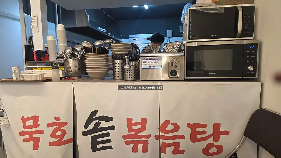 정돈된 주방 앞 공간과 쌓인 식기류