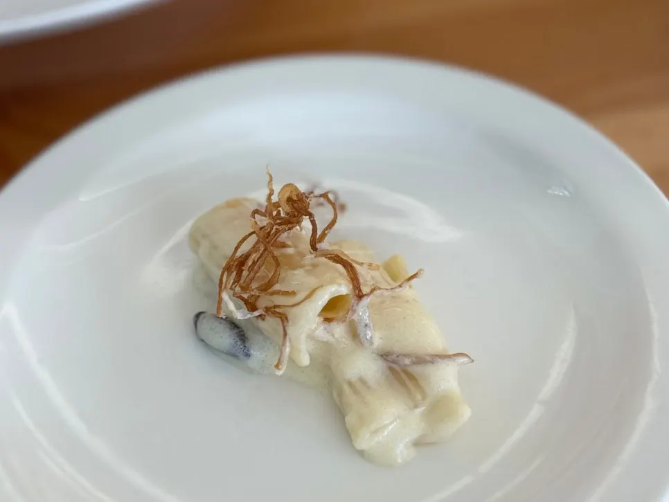 Truffle cream pasta topped with enoki mushrooms