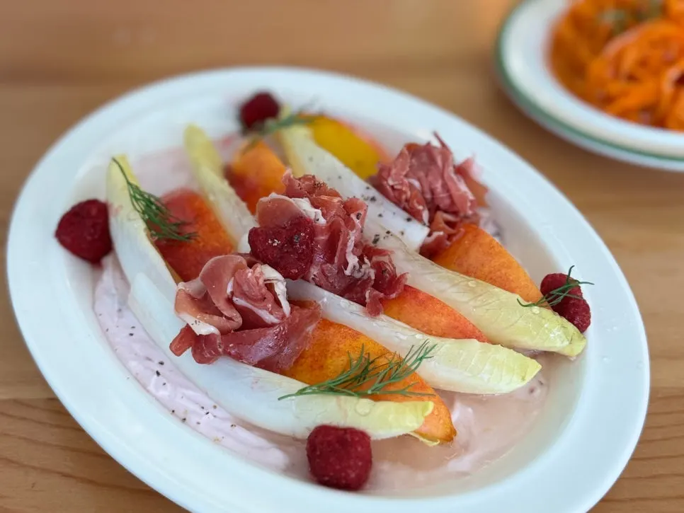 Salad combining peach, jamón, and raspberry yogurt