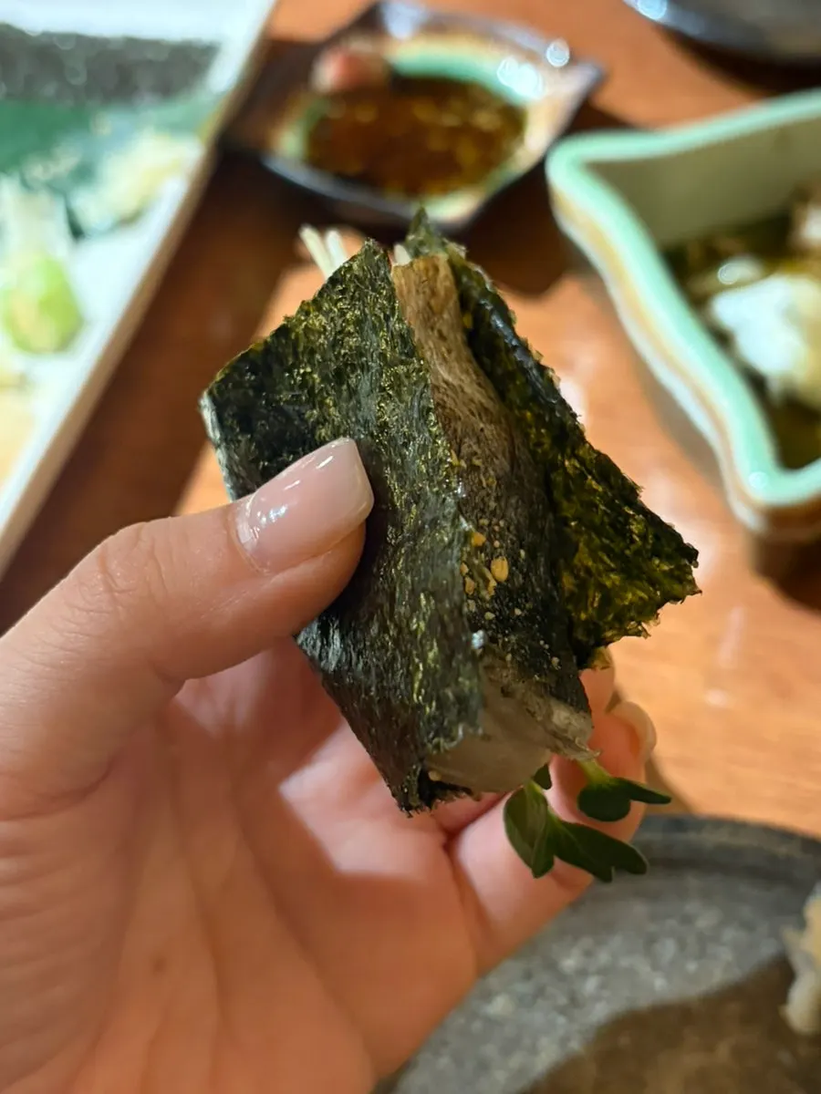 Wrapping the mackerel bongcho sushi in seaweed before eating