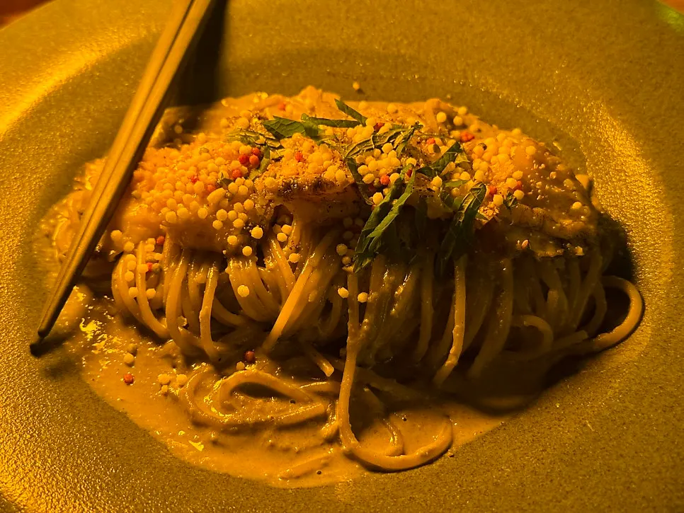 Close-up of the cream pasta topped with abalone, perilla leaves and arare