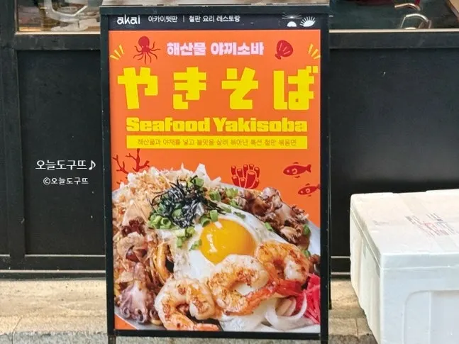 Outdoor promotional sign mentioning seafood yakisoba