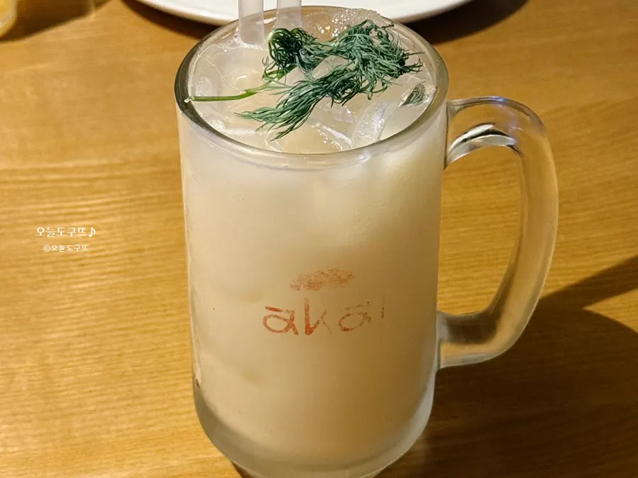 A glass of yogurt highball topped with herbs