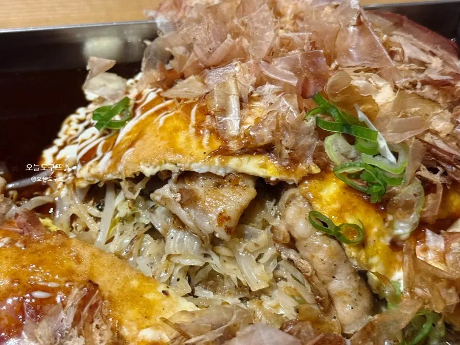 Hiroshima-style okonomiyaki drizzled with sauce and mayo