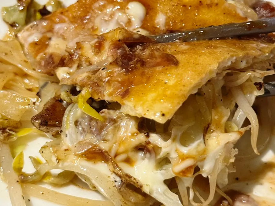 Cross-section of the okonomiyaki showing soba noodles and pork