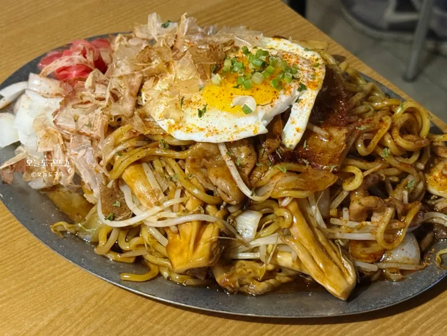 Pork belly yakisoba topped with a soft-boiled egg