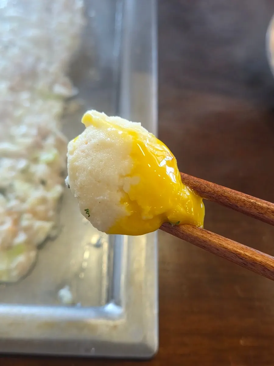 Waterfall potato topped with soft-boiled egg and onion flakes