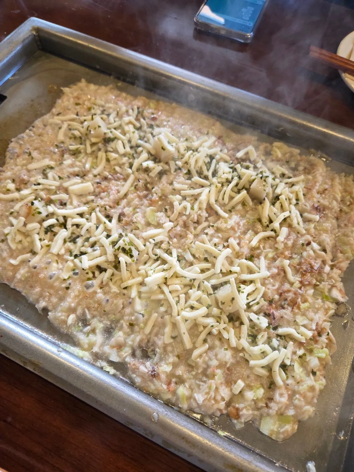 Mentaiko monjayaki cooking with cheese sprinkled on top