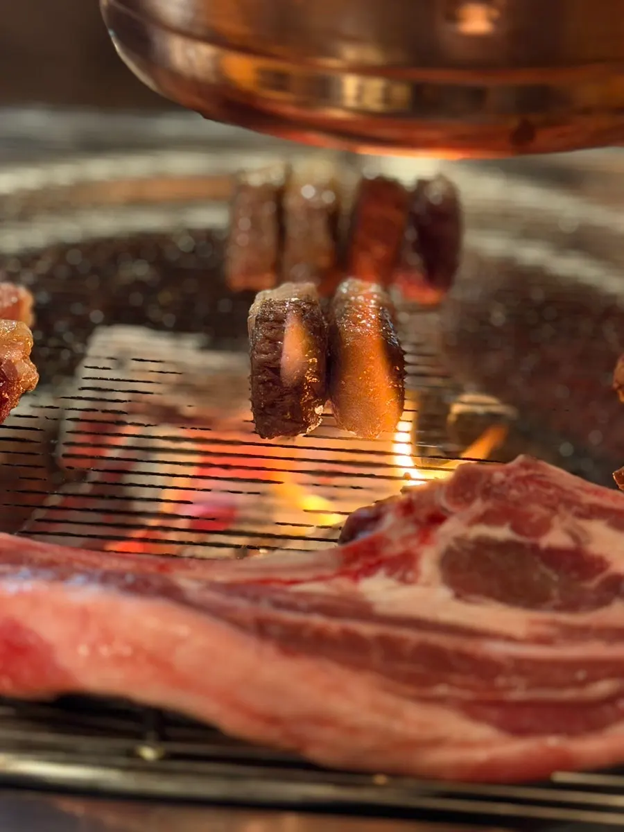 Staff grilling the lamb directly for guests