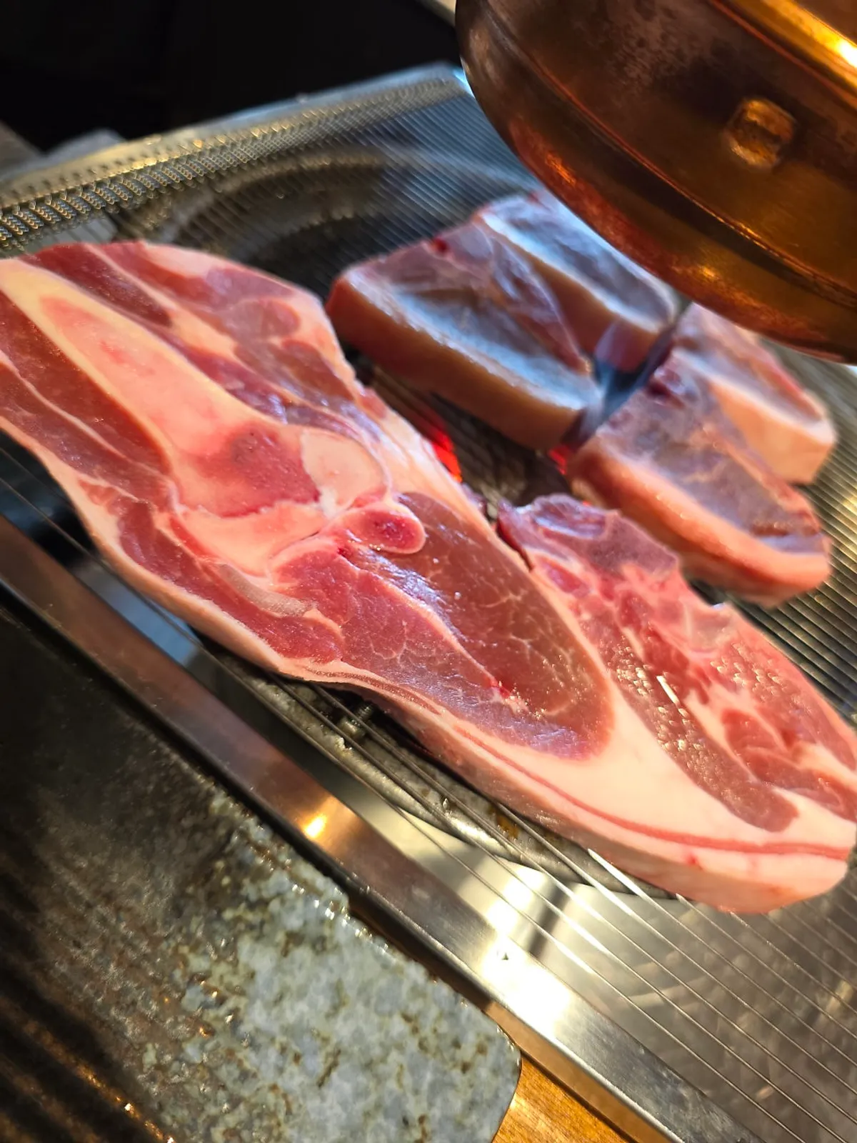 Thick T-bone lamb grilling over charcoal