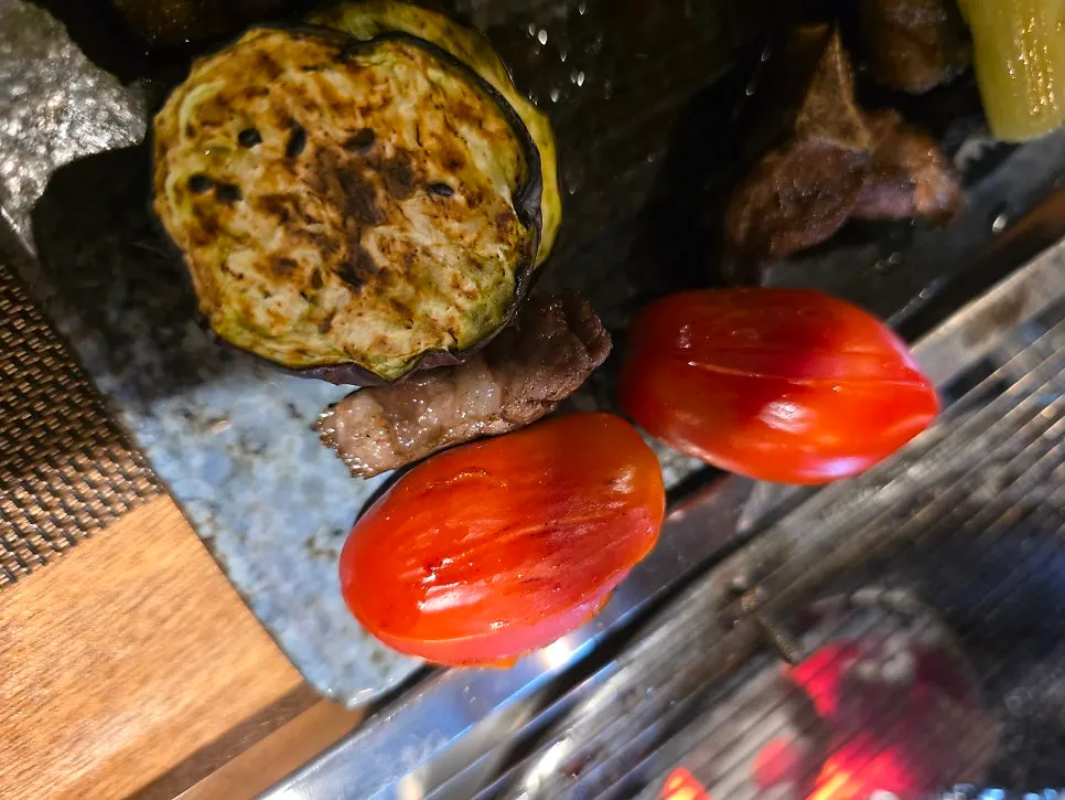 Grilled vegetable garnish of eggplant, cherry tomatoes, and scallion