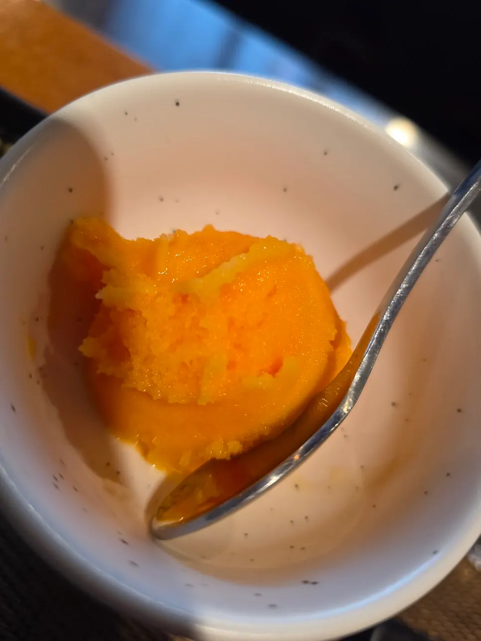Bright orange fruit sherbet served to end the course