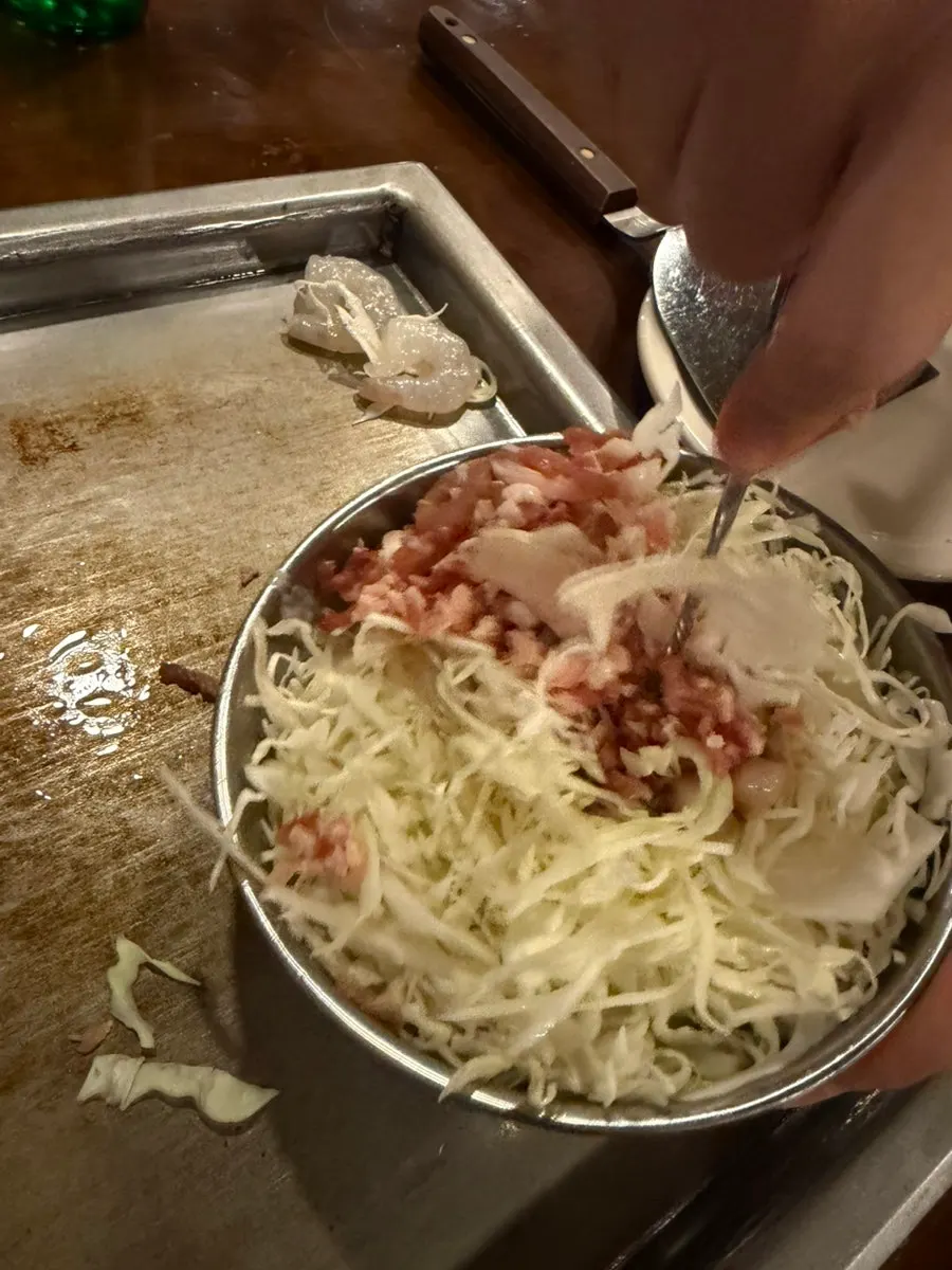 Bowl of okonomiyaki batter with cabbage and seafood