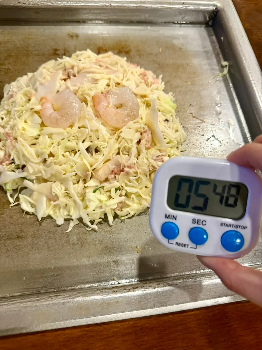 Okonomiyaki topped with cheese and green onion