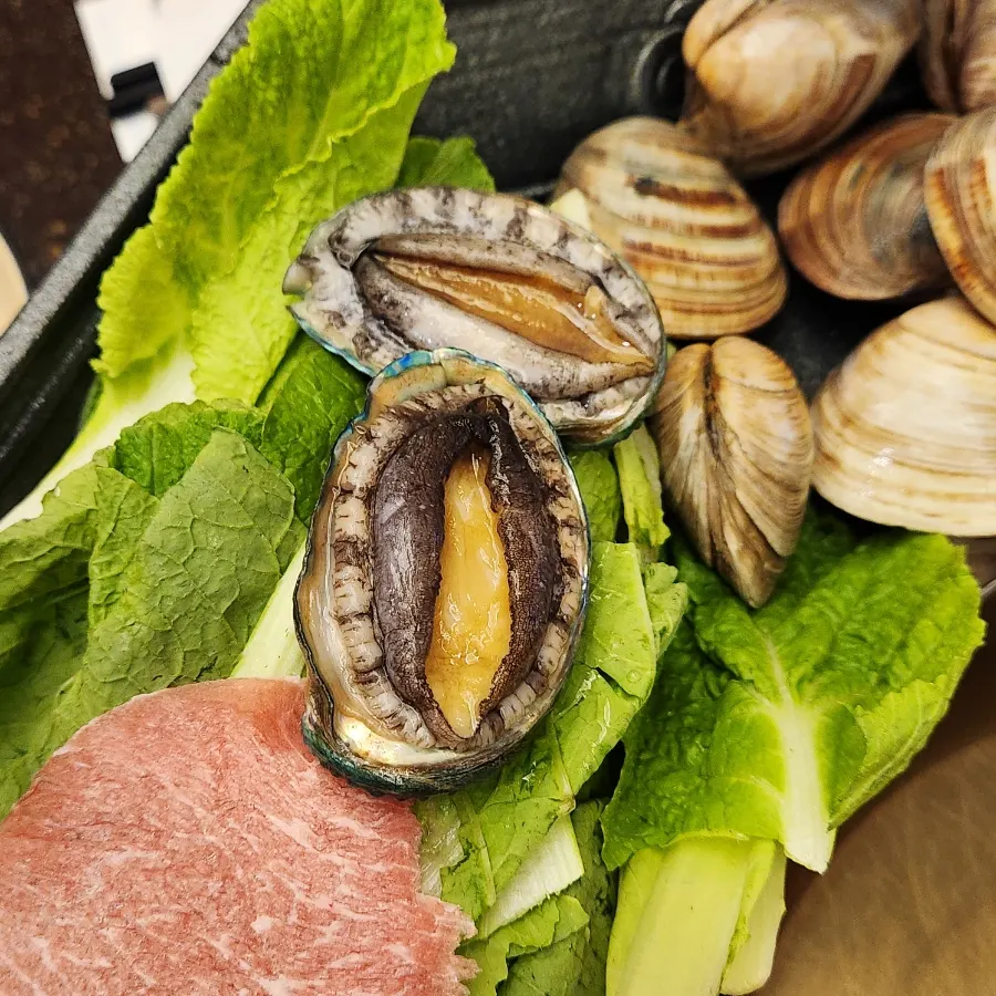 Abalone, clams, and shabu meat arranged together