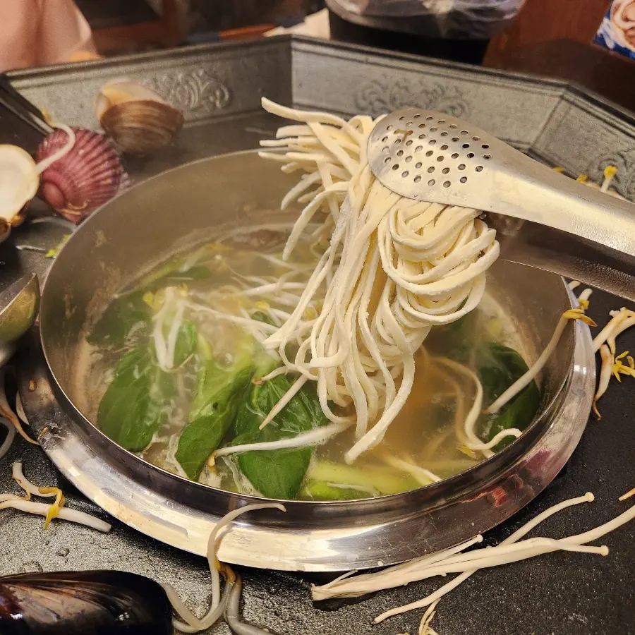Kalguksu noodles added into the clam broth
