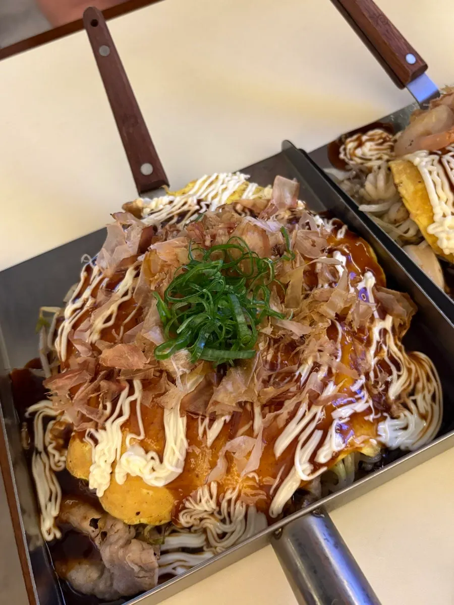 Akai okonomiyaki yang disajikan di atas pelat besi