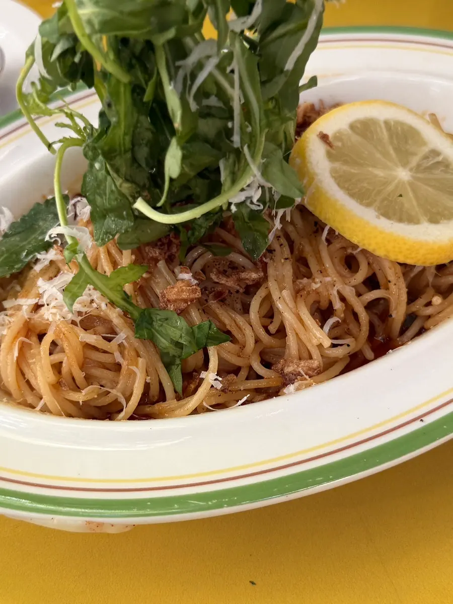 Spicy lemon anchovy pasta topped with arugula