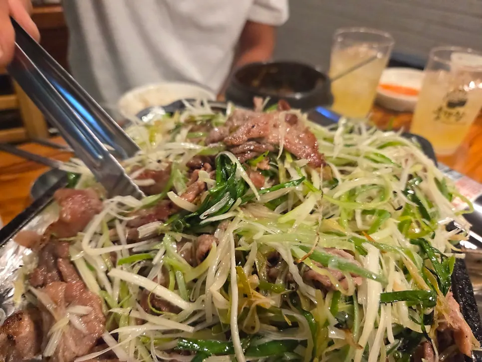 Fully cooked charcoal scallion bulgogi being tossed