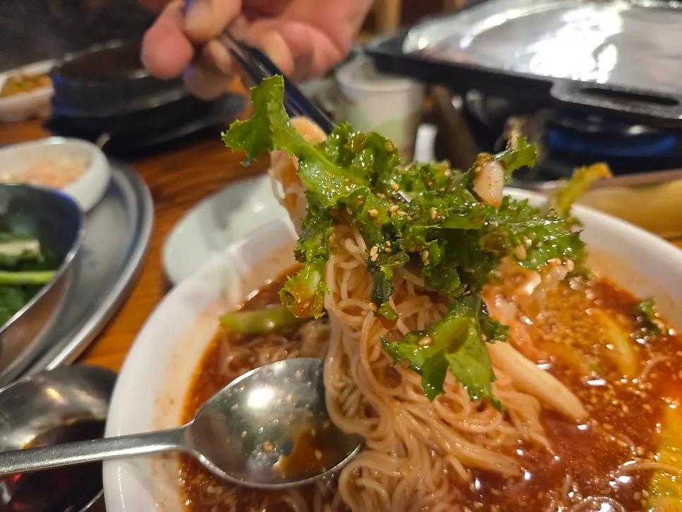 A bite of bibim noodles eaten with bulgogi