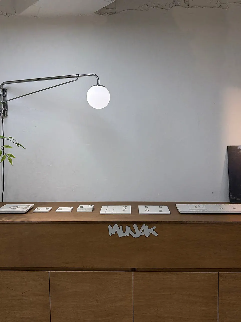 Jewelry design samples displayed on Munak's wall