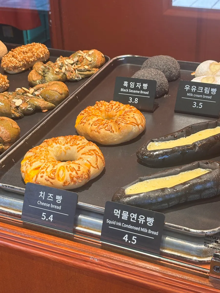 Various types of bread laid out on Munhwa Bakery's display shelf