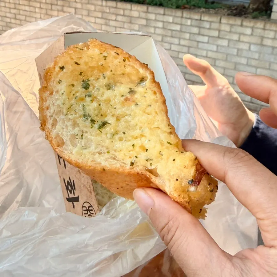 Eating Munhwa Bakery's garlic bread on the street