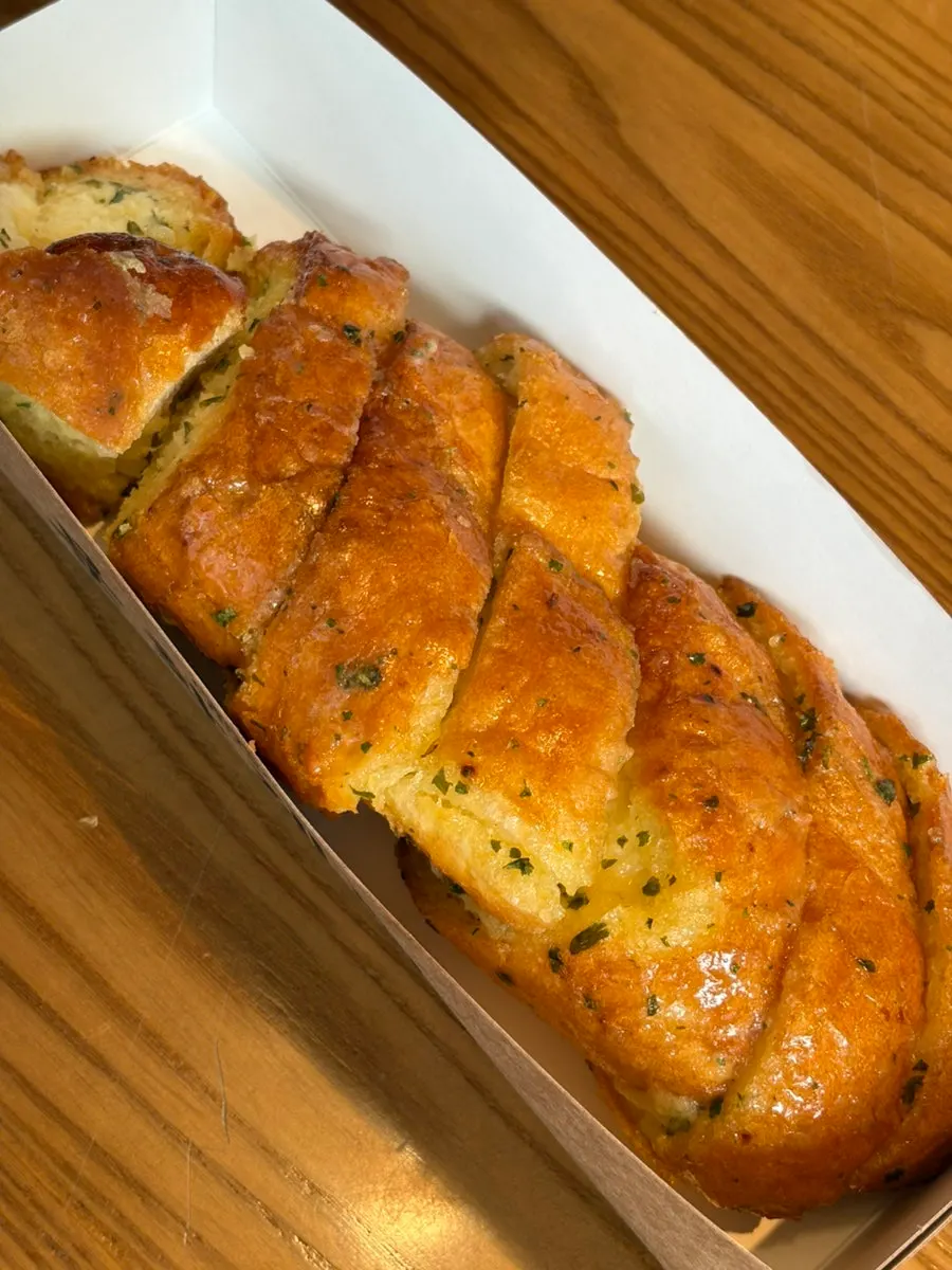 Close-up cross-section of a bite-sized piece of Munhwa Bakery garlic bread
