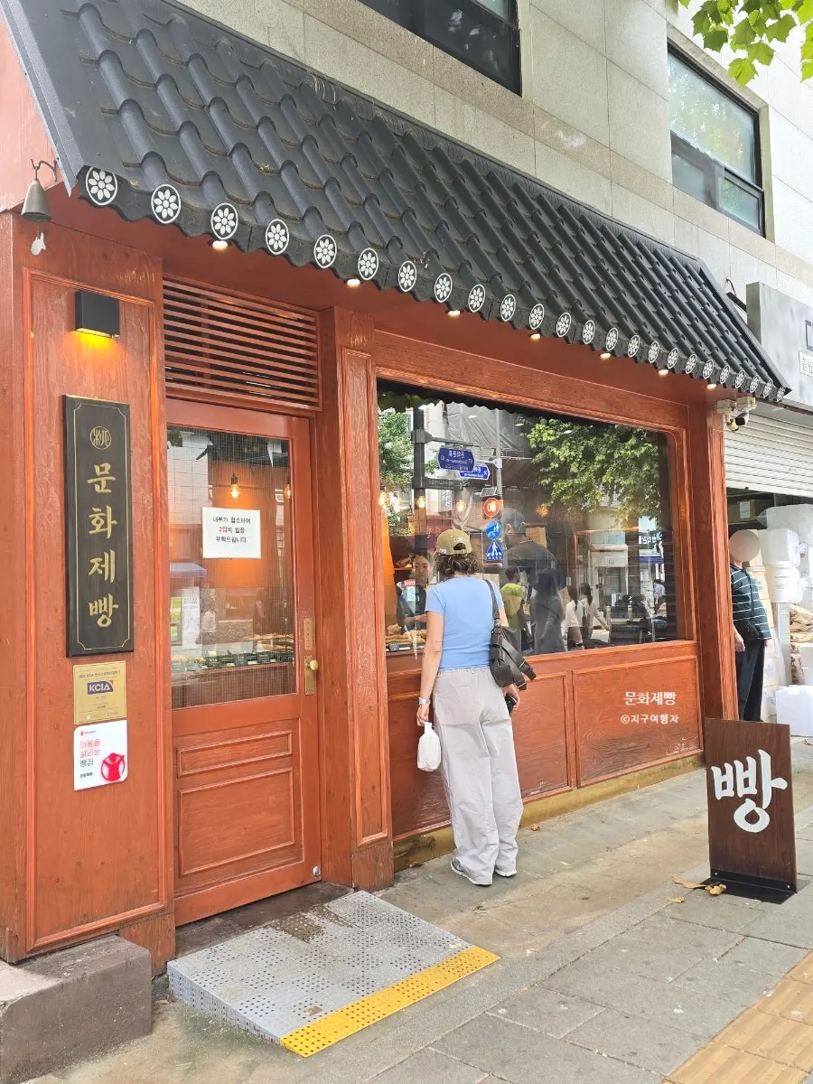 Shop entrance with Munhwa Bakery's business hours posted