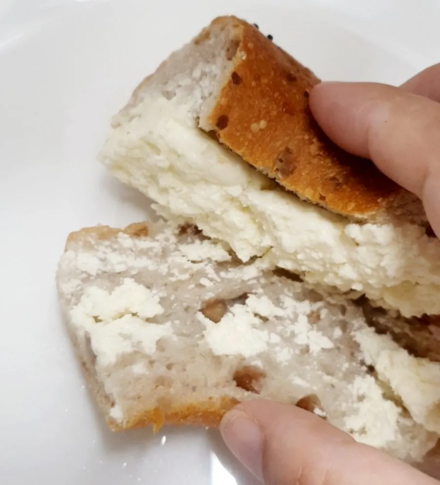 A piece of garlic bread held in hand