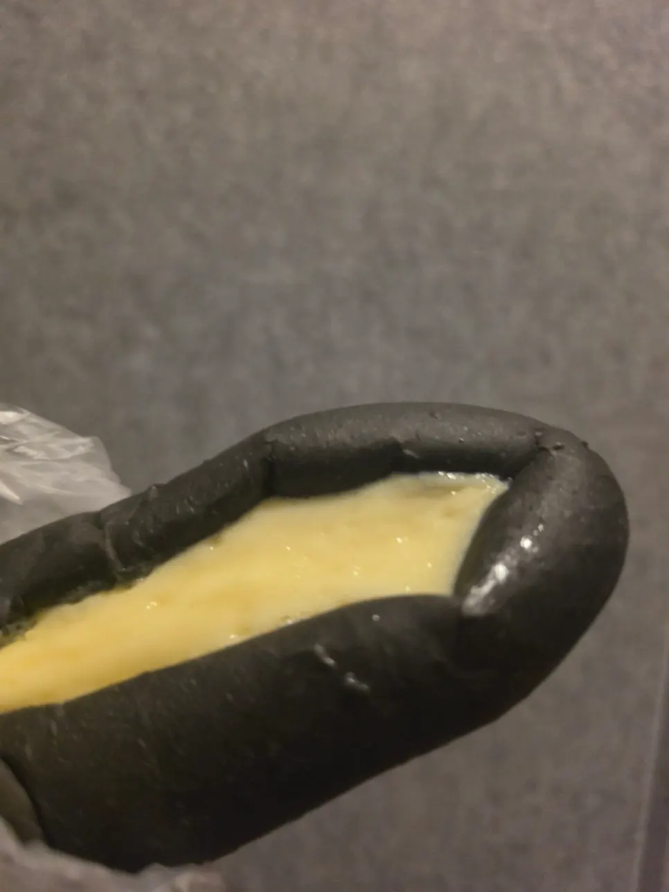 Bitten-into squid ink condensed milk bread showing the filling