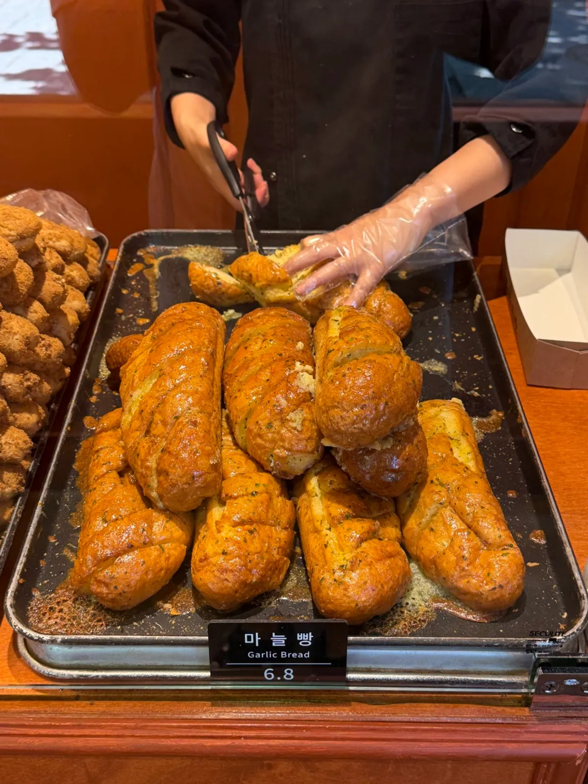 Munhwa Bakery's large garlic baguette topped with garlic sauce