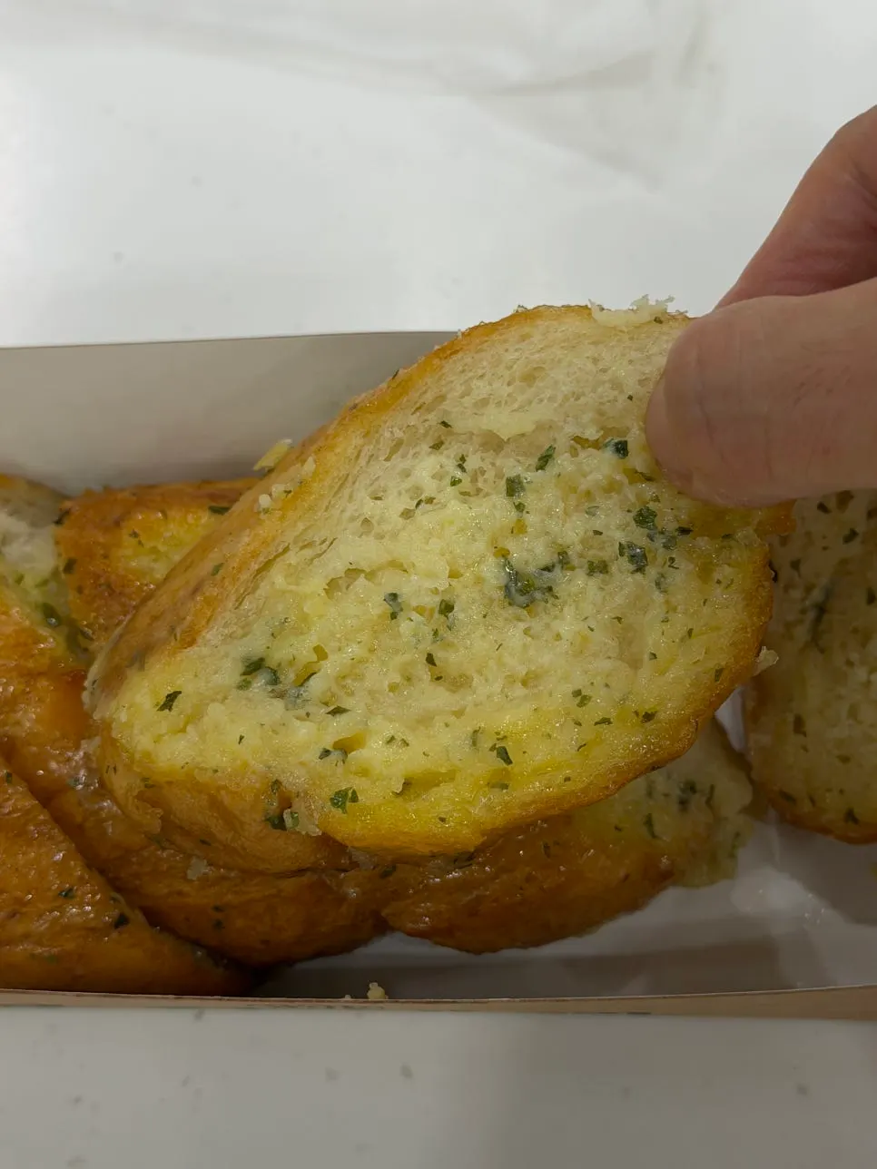 Sliced garlic baguette pieces served on a plate at home