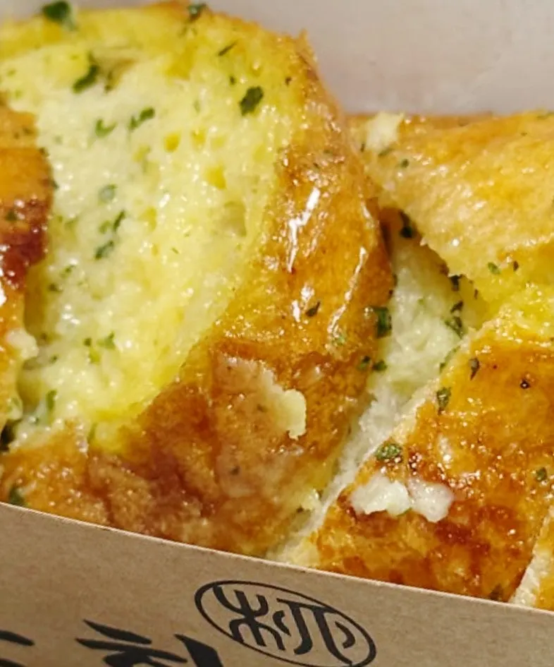 Cross-section of the garlic baguette topped with garlic sauce