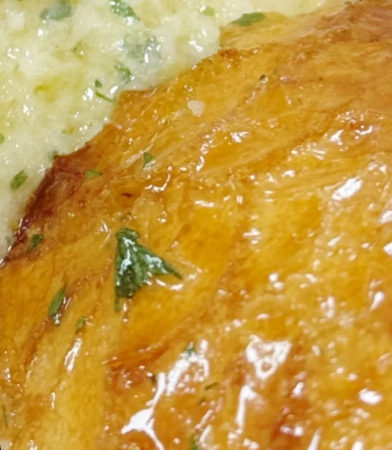 Torn bite-sized piece showing the inside of the garlic baguette