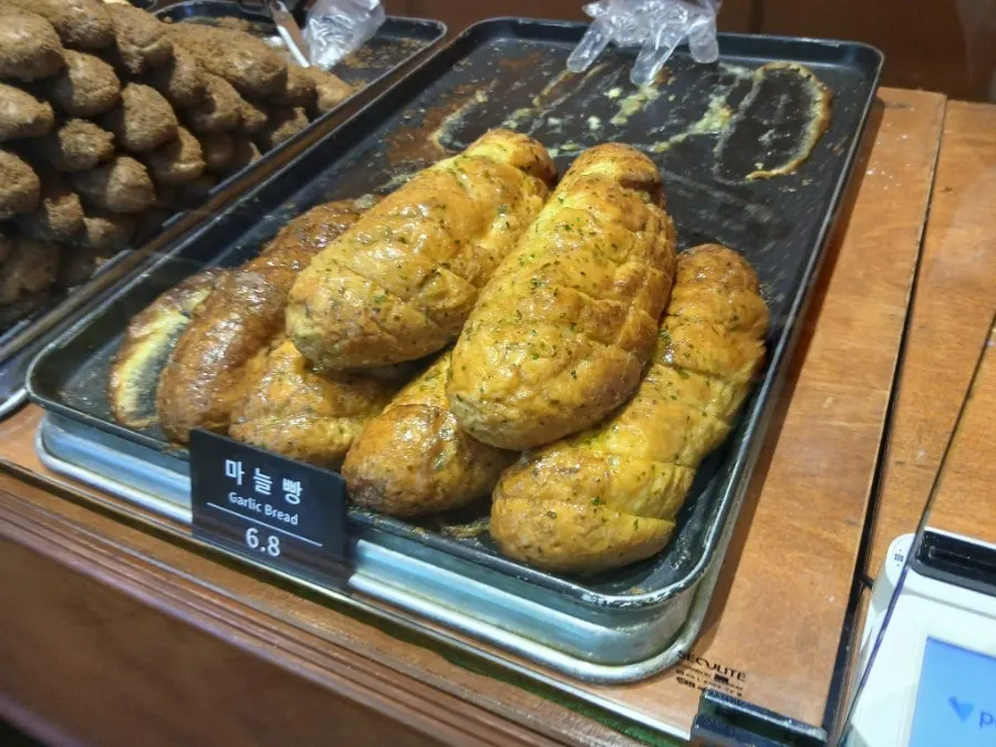 Garlic baguette served alongside an americano