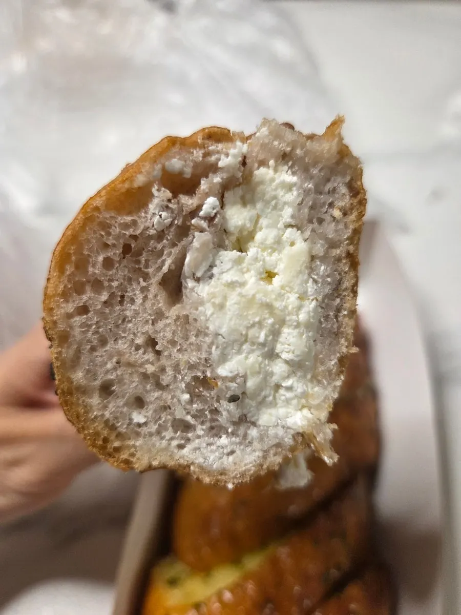 Cross-section of the onion bagel showing cream cheese and nuts