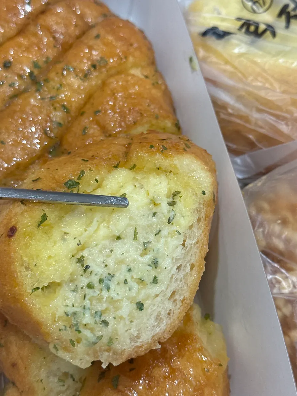 Cross-section of garlic bread packed with garlic sauce
