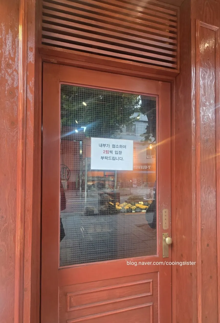 Front of Munhwa Bakery with a sign about entering in two parties at a time