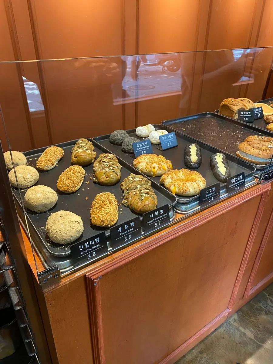 Display shelf at Munhwa Bakery with injeolmi bread, peanut bread, and mugwort rice cake bread