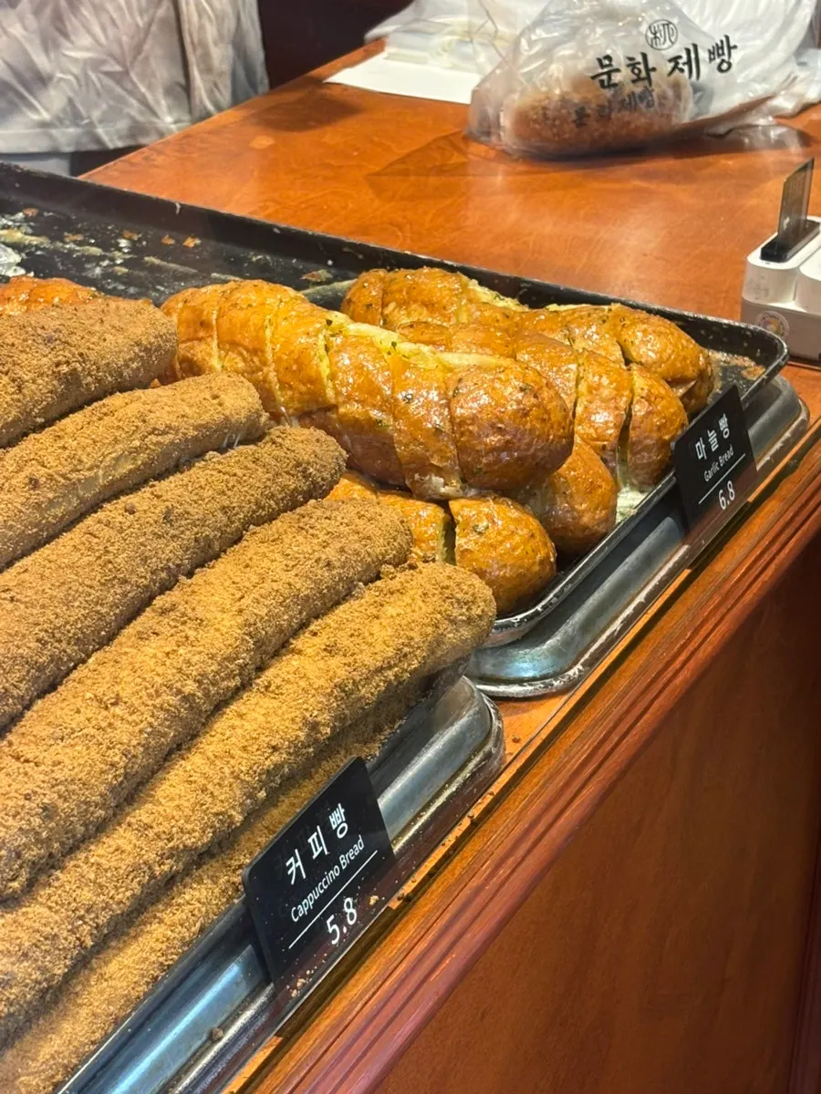 Bread display shelf with name labels at Munhwa Bakery