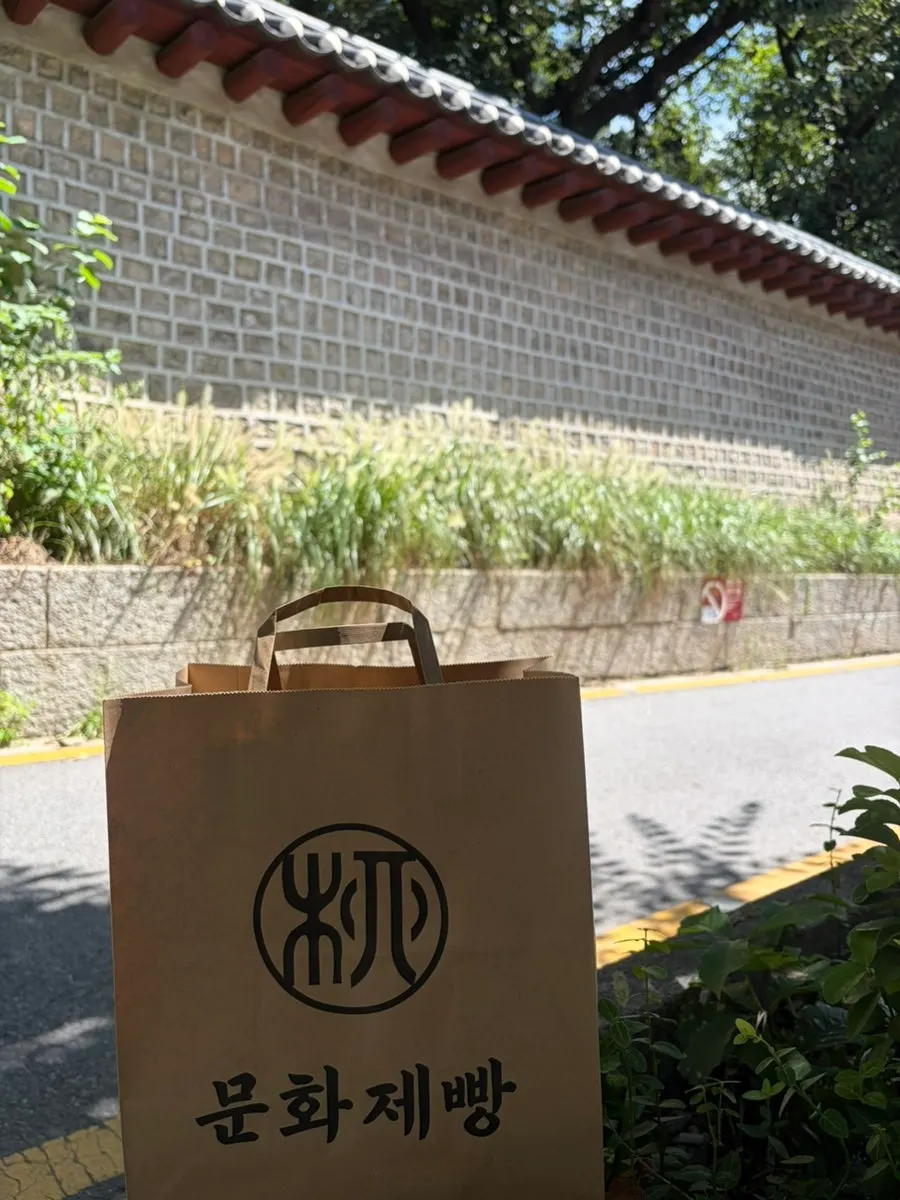 Bread bag held in front of the Seosullo-gil stone wall