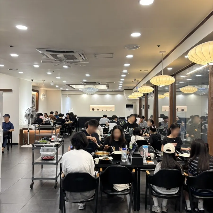 The busy dining hall seating at Yunujae Munhyeon Shabu Kalguksu