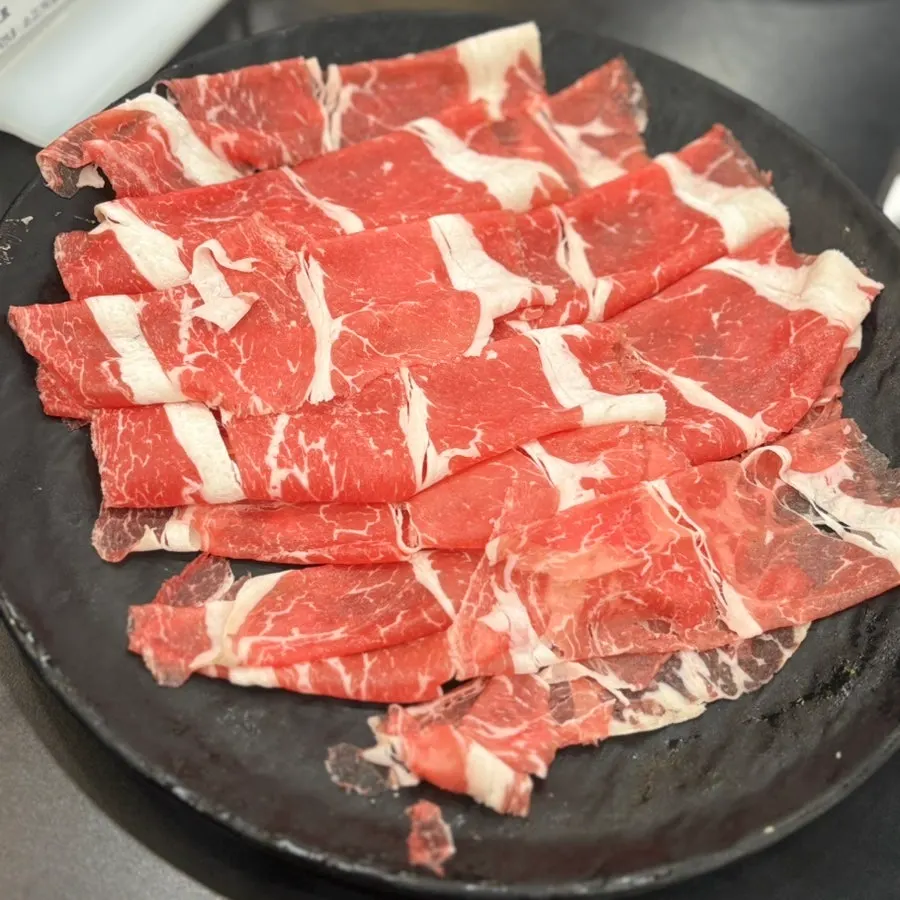 A pot of spicy shabu broth loaded with minari